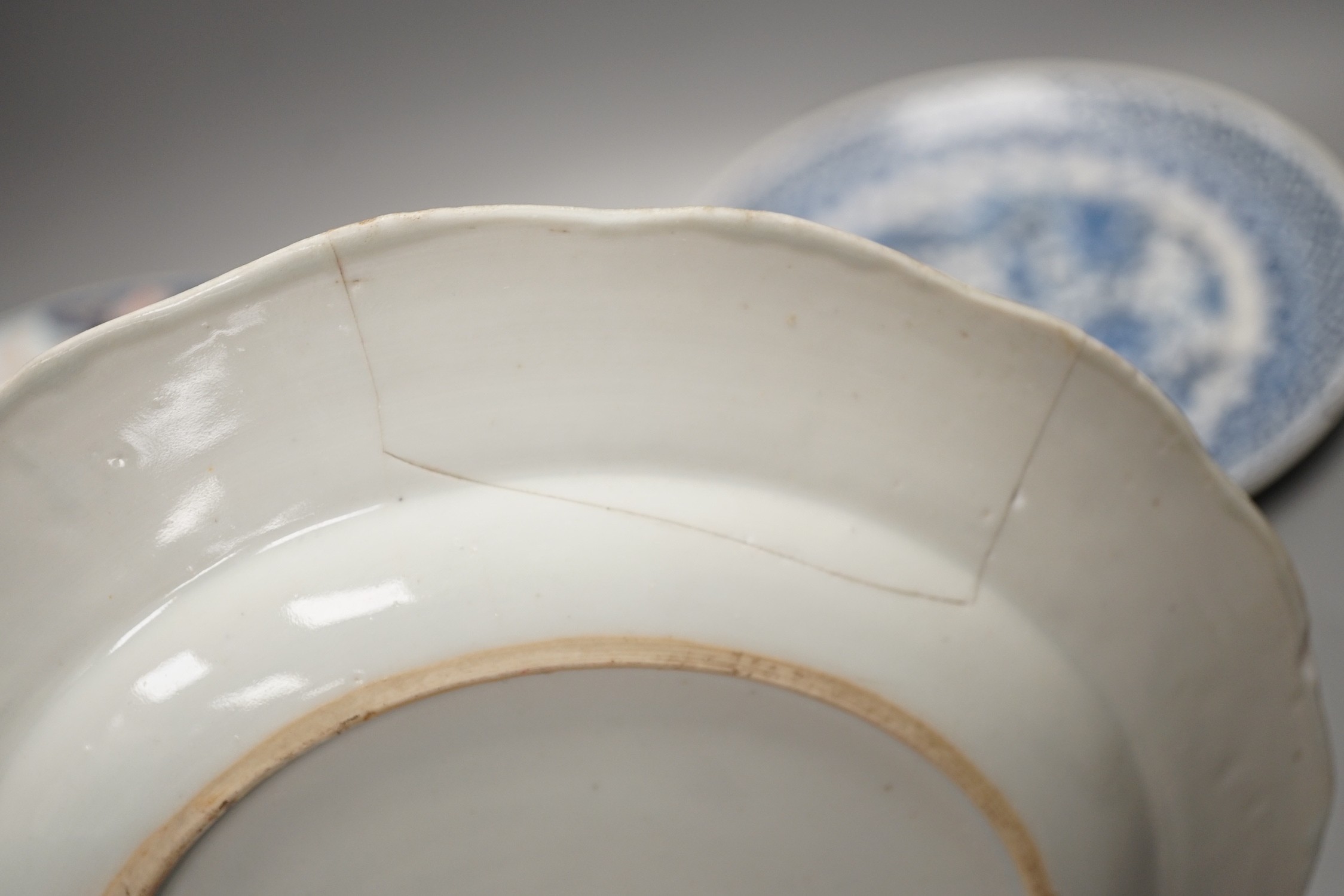 Four Chinese 18th century plates and a late 19th century blue and white dragon plate, largest 24cm diameter